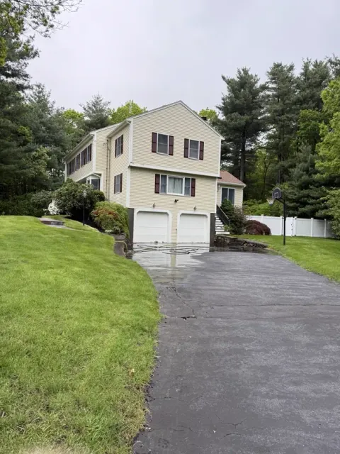 Yellow colonial and driveway after a Callahan house wash