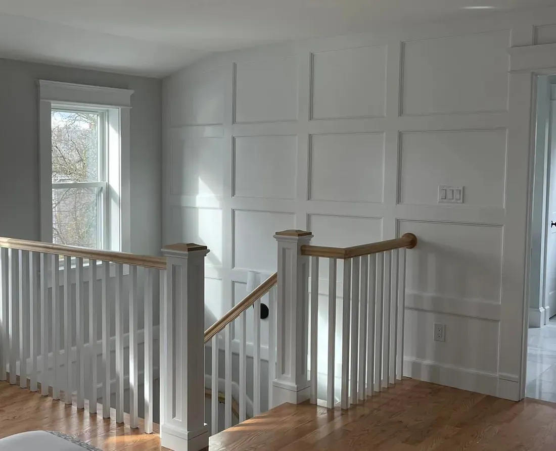 Close view where the staircase meets fitted panel millwork at a landing