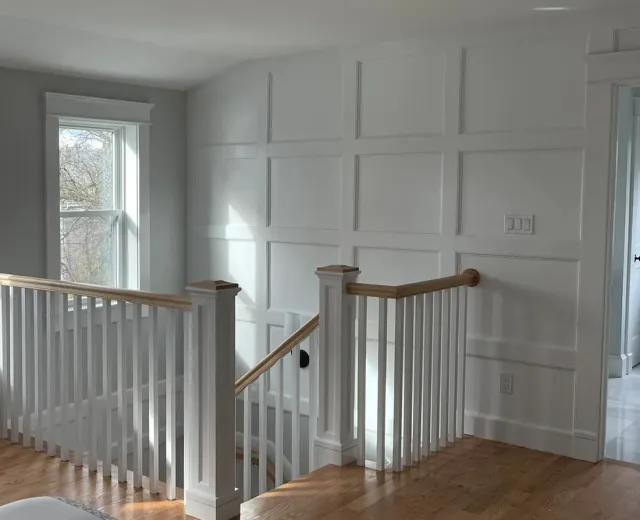 Close view where the staircase meets fitted panel millwork at a landing