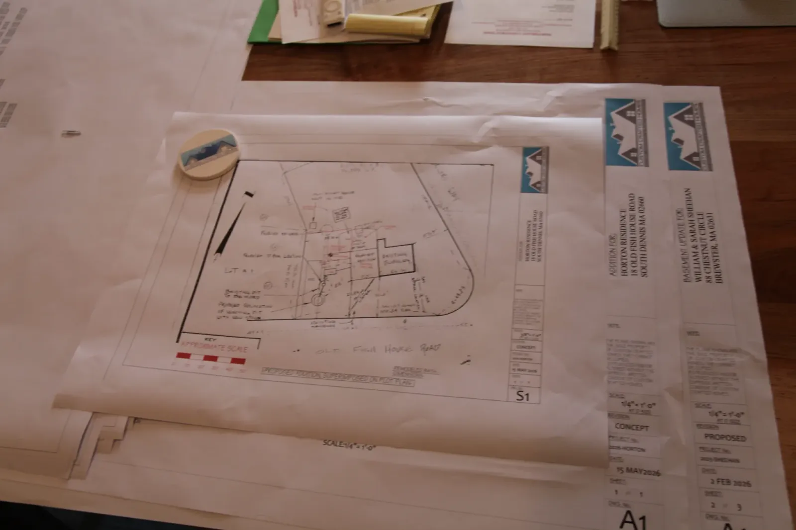 Architectural site plan and blueprints spread across a table