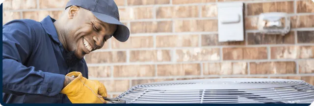 worker smiling fixing HVAC unit