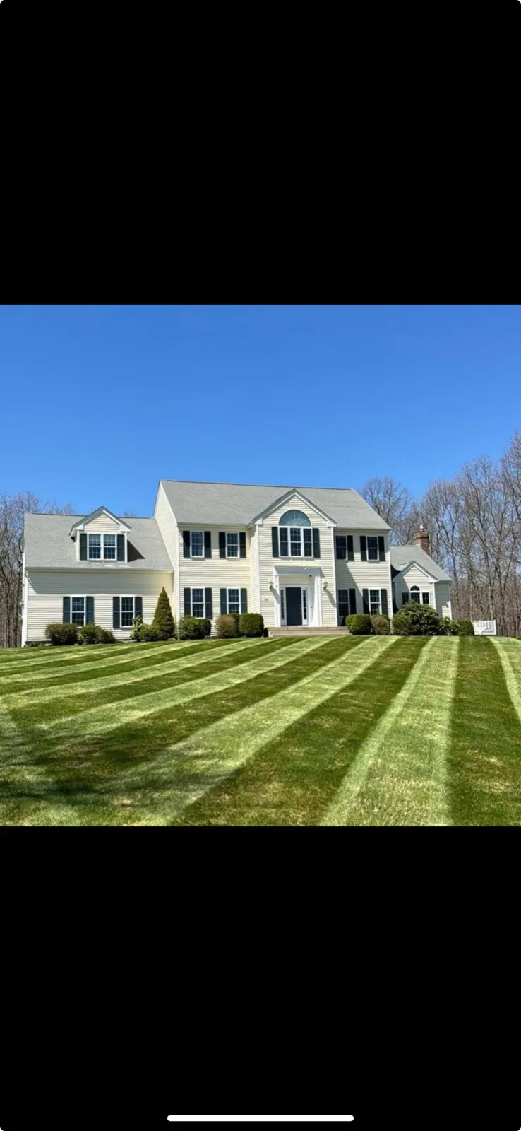 A large white house with a lush green lawn in front of it.