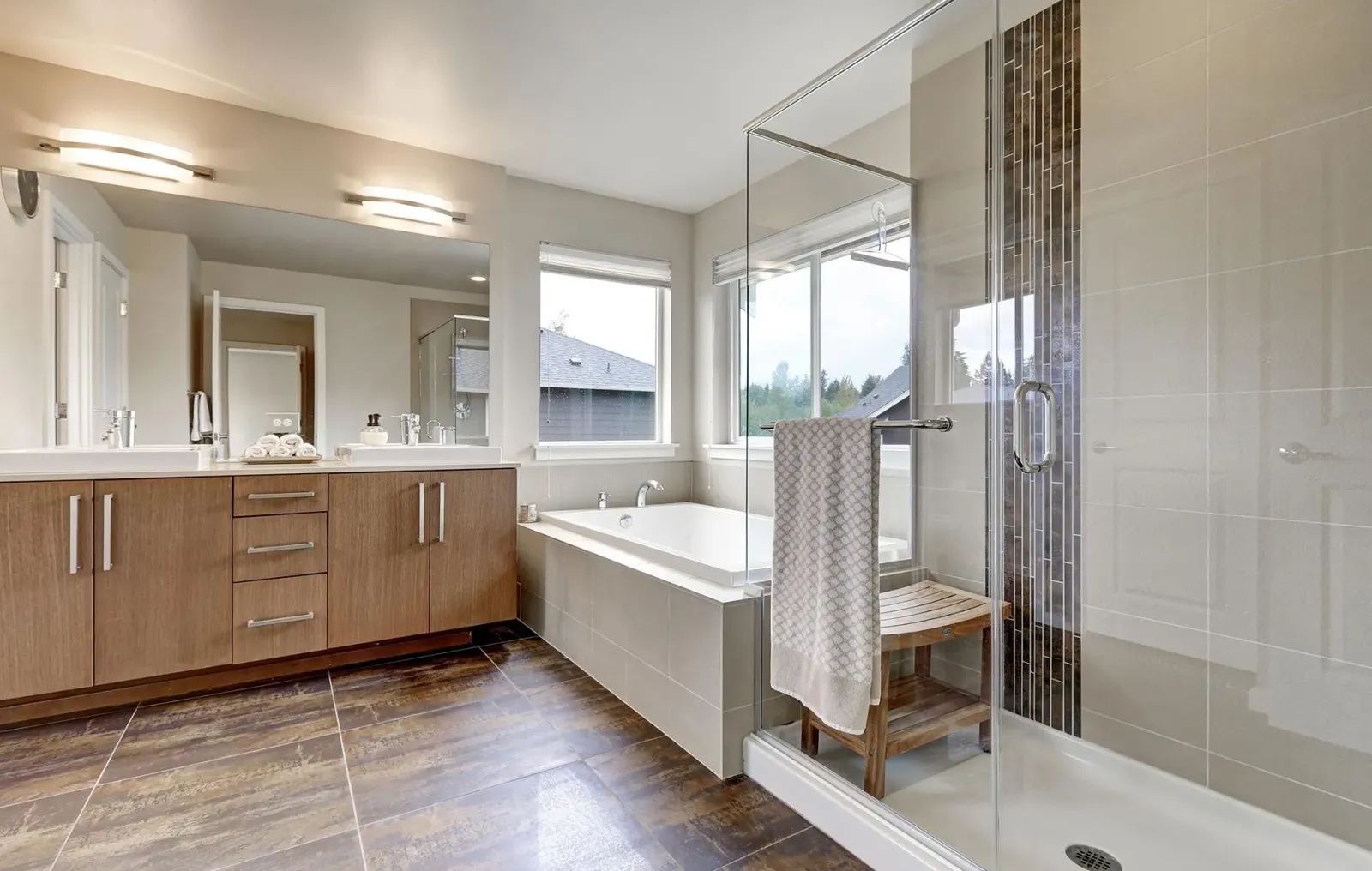 A bathroom with two sinks , a tub , and a walk in shower.