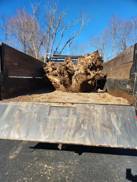 Large rusted metal scrap on a flatbed trailer under a clear blue sky