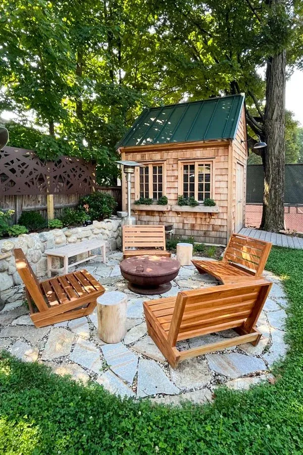 Informal outdoor stone patio seating area set in micro clover lawn