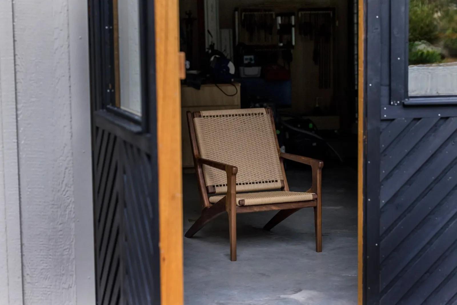 A solid maple lounge chair with danish cord featured inside the woodshop studio. This chair is known as the salt marsh chair.