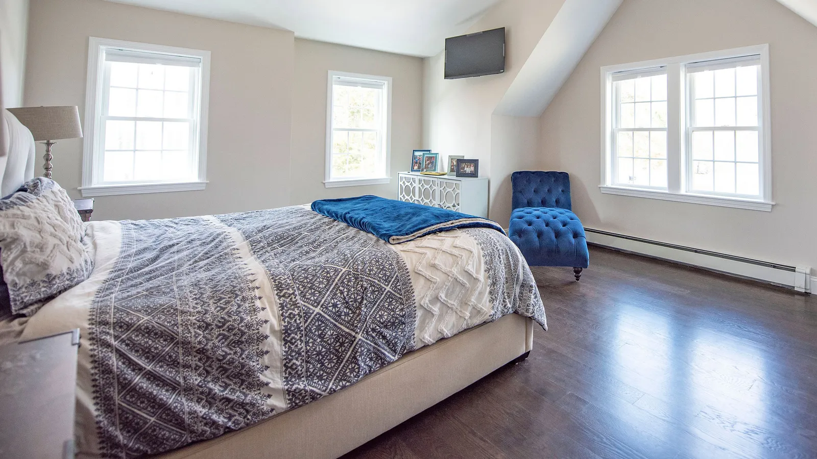 This custom home renovation features a 3rd story addition with bright modern bedroom, hardwood floors, new vinyl windows, and walkout deck with views of the ocean.
