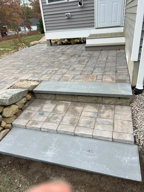 A brick walkway with steps leading up to a house.