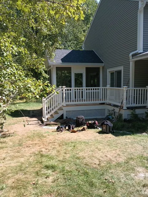 Finished Bedford deck rebuild and four-season porch addition with white PVC railings