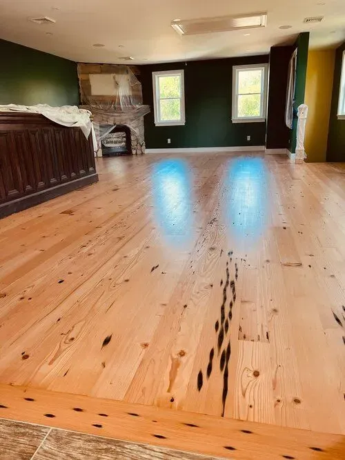 A large room with a wooden floor and a fireplace.