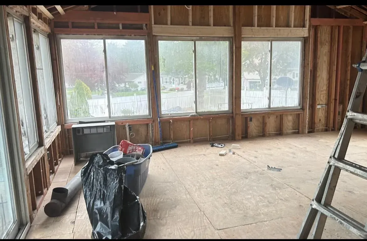 A room with a lot of windows and a ladder in it