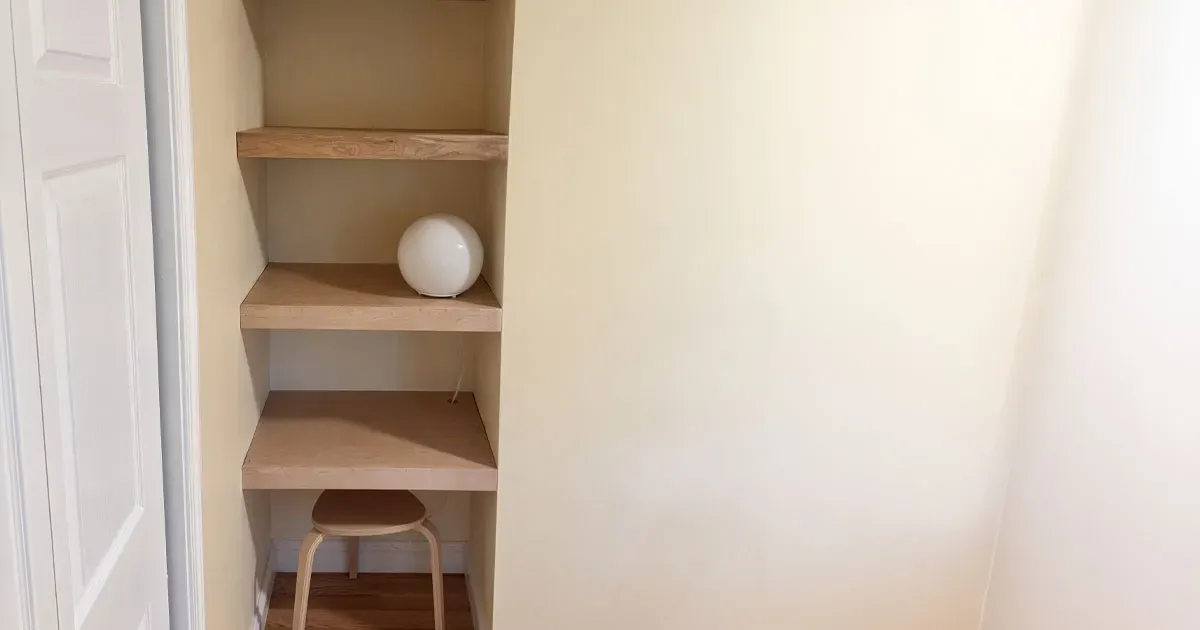 Custom wood built-in shelving installed into a wall recess for storage and display