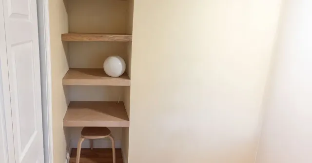 Custom wood built-in shelving installed into a wall recess for storage and display