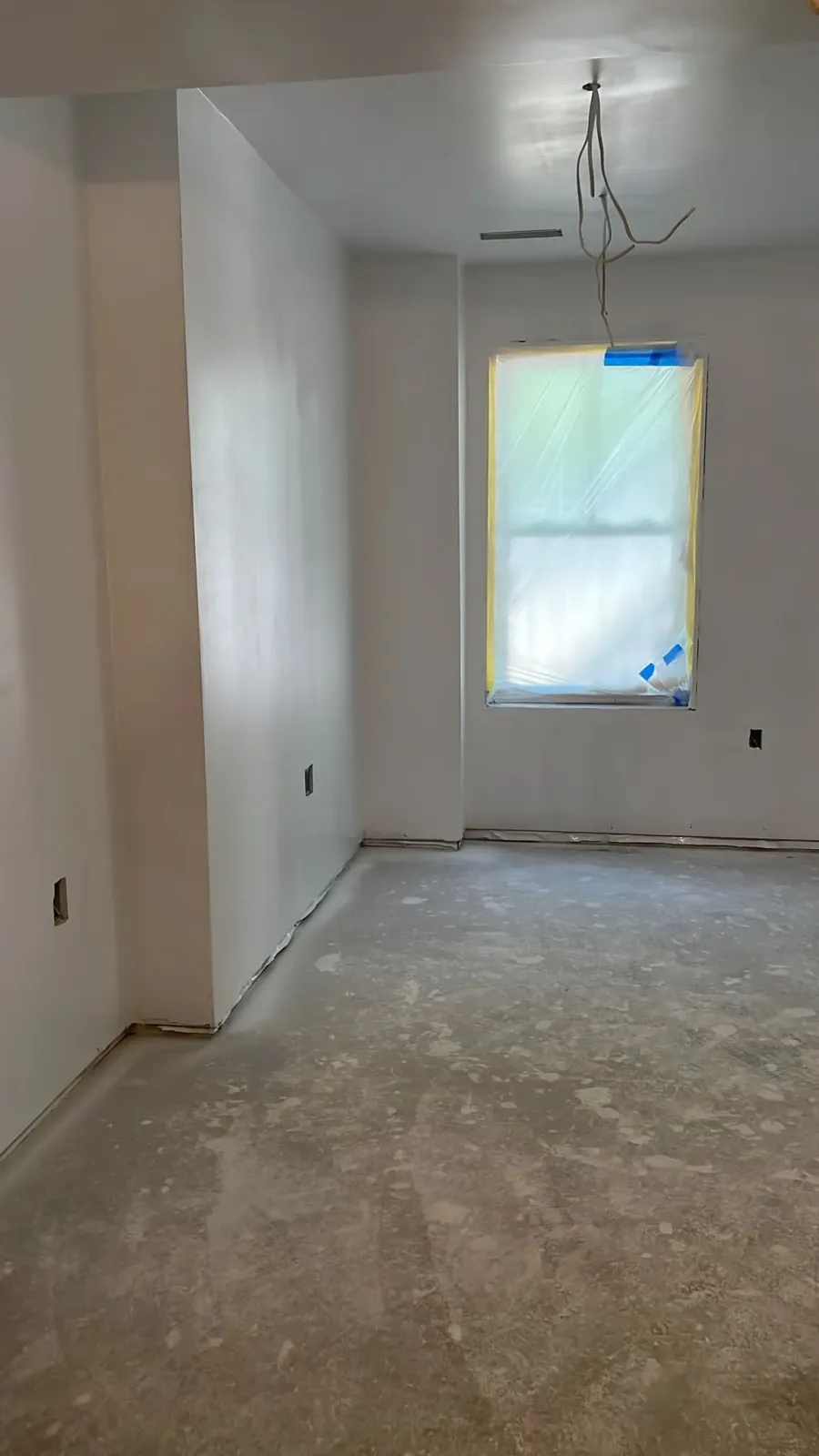 An empty room with white walls and a window.