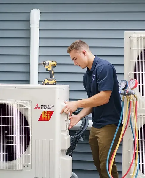 Mitsubishi Mini Split outdoor unit being serviced by a trained technician.