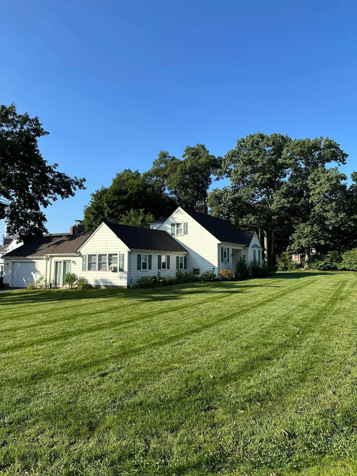 Freshly striped green lawn in front of a New England home