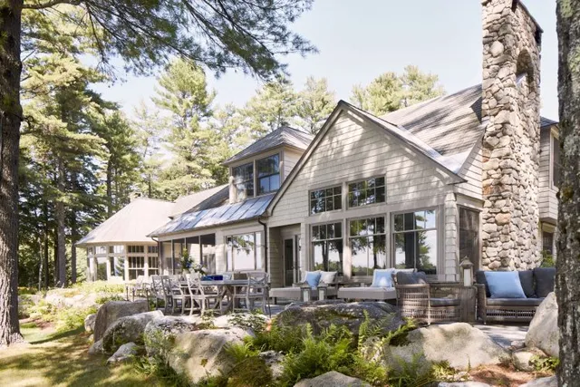 Elegant residential home with large windows nestled among trees in Maine.