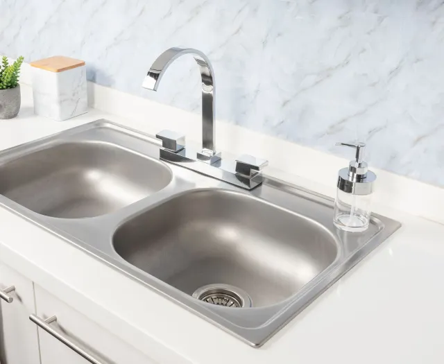 A person is fixing a sink with a wrench