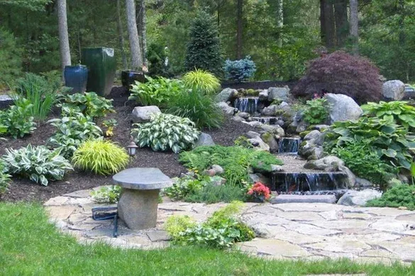 Water feature and shade planting with flagstone patio