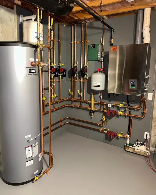 a room with a water heater and a lot of pipes