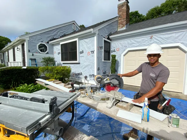 Expert contractors from Fernandes Construction using speciality equipment to add insulation and trim to house