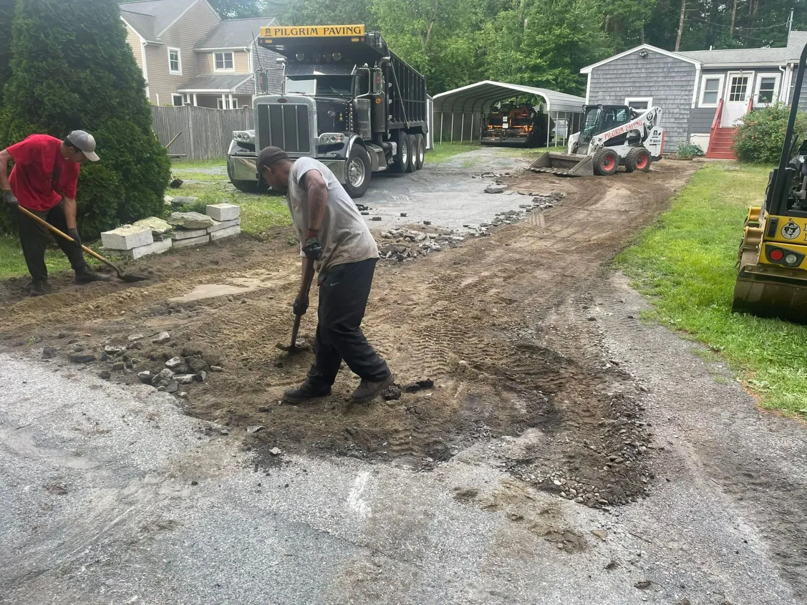 a man is standing next to a dump truck in a parking lot .
