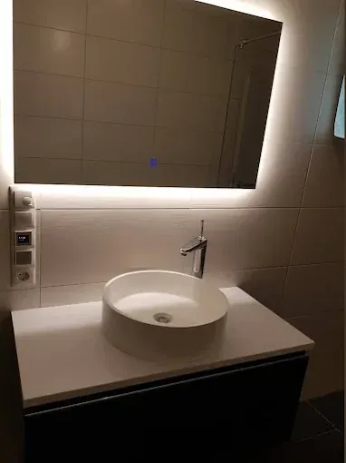 Finished bathroom vanity with vessel basin, tall mixer tap and backlit mirror