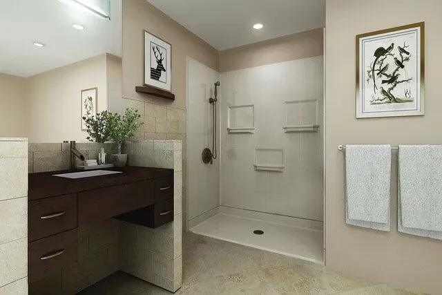 Modern beige bathroom with vanity, shower, towels, and framed wall art
