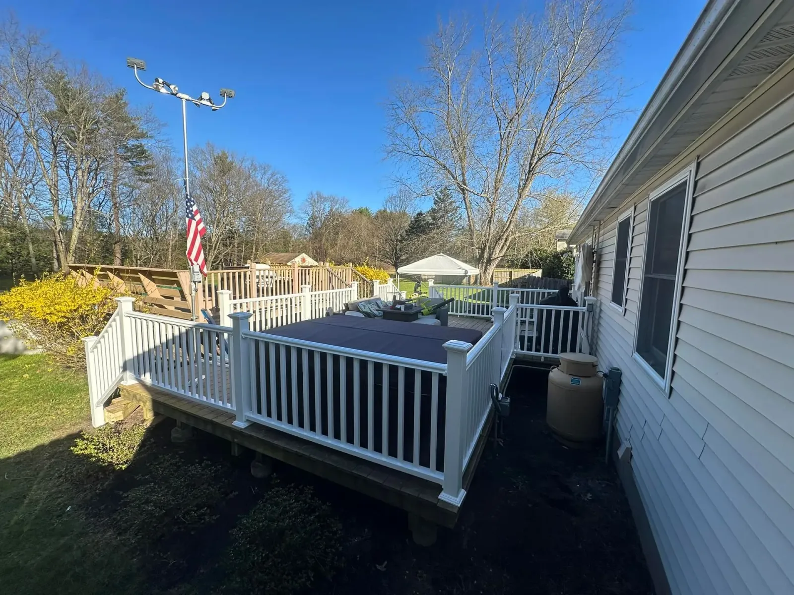 A white house with a large deck in front of it.