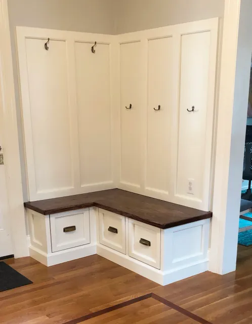 Custom storage created for the front foyer of the client's historic carriage house, designed to match the original wainscoting on their stairs