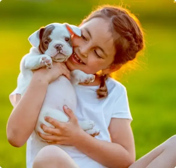 Little girl smiling holding a dog after her yard has been treated by ohDEER's all natural mosquito and tick control spray.