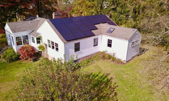A home with a large modern solar panel system installed on the roof.