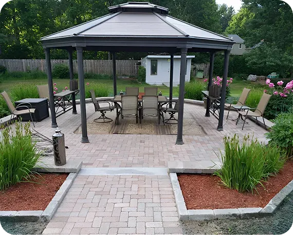 Paver patio with a gazebo, seating and stone-edged planting beds