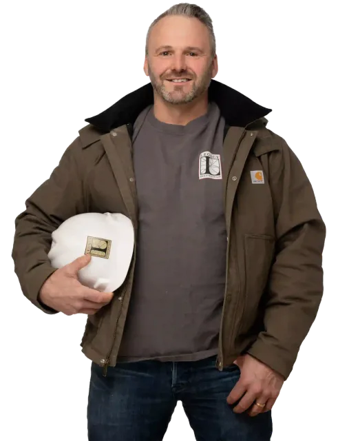 Smiling man in brown jacket holding a white hard hat, standing against a white background