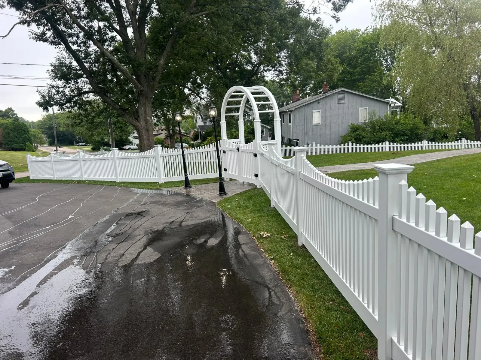 A white picket fence along the side of a road.
