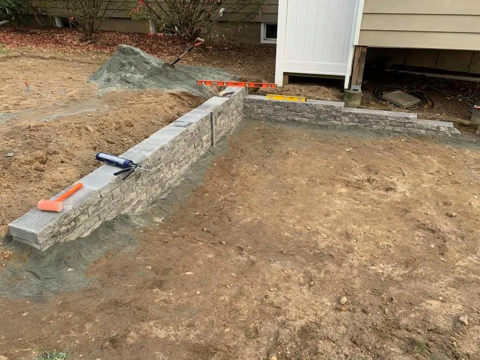Custom garden wall with new plants and bark mulch
