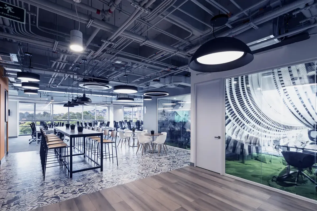 Modern commercial office interior with pendant and ring LED lighting installed across an exposed ceiling