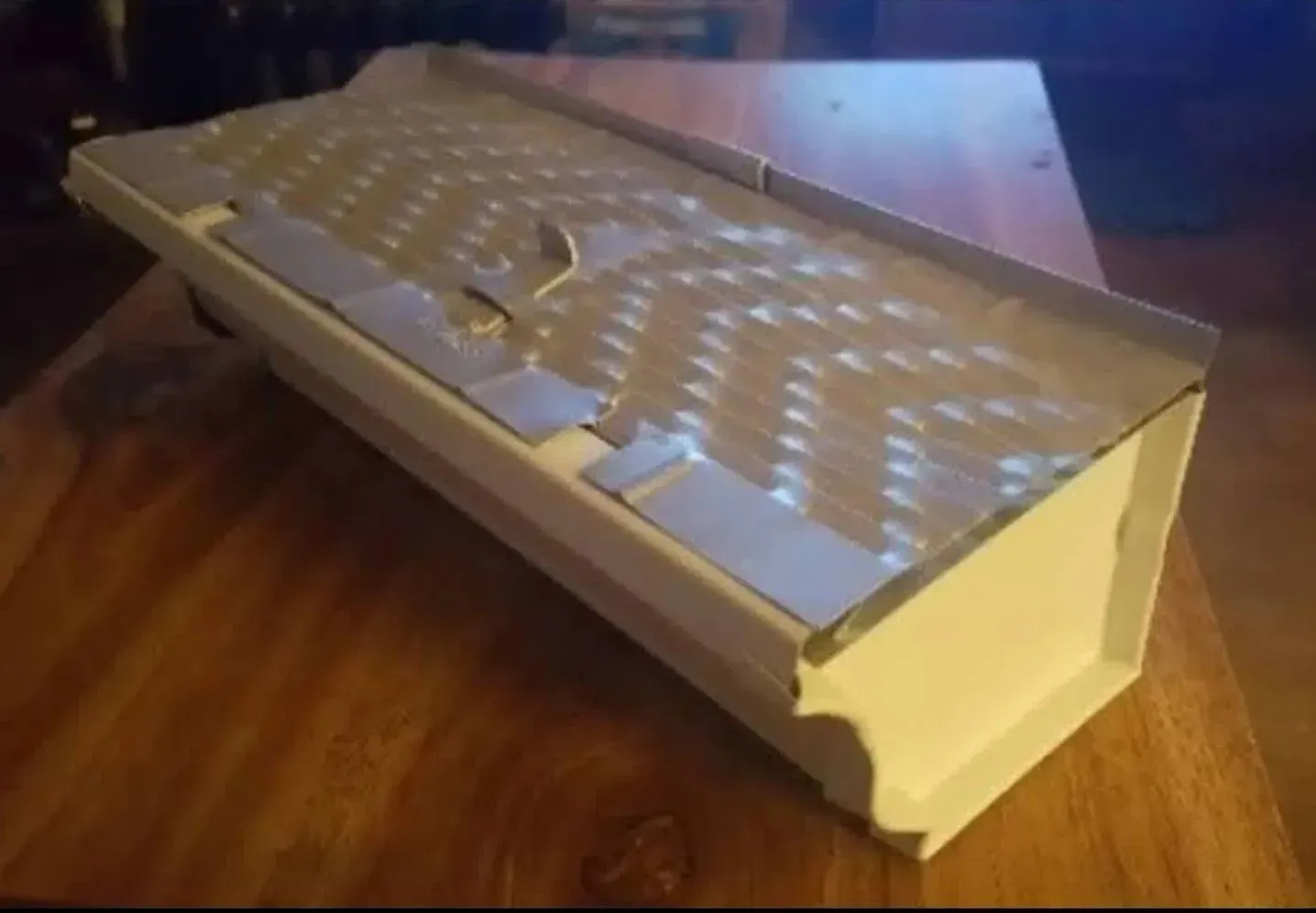 White foam packaging insert lying on a wooden table.