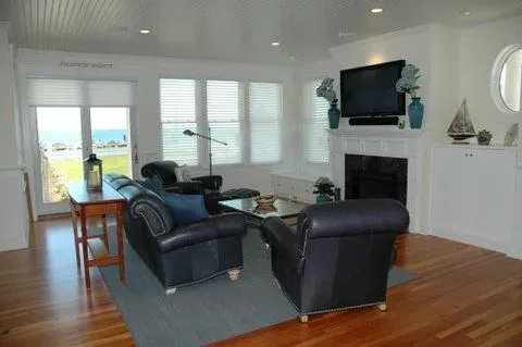 A living room with a couch , chairs , a fireplace and a flat screen tv.