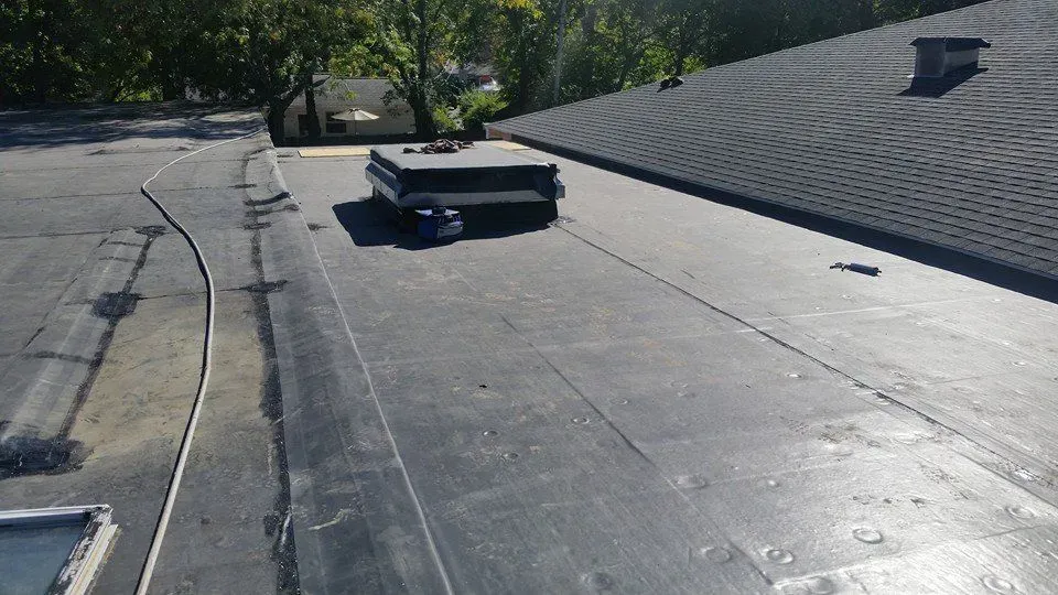 A black roof with a chimney on top of it.