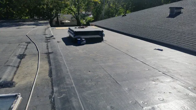 A black roof with a chimney on top of it.