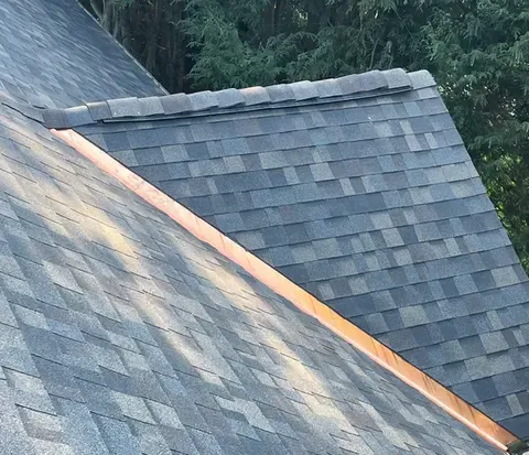 Wide view of Owens Corning Duration shingles with copper valley flashing along the roof edge, Worcester, MA