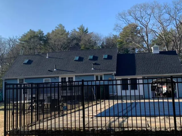 A house with a pool behind a metal fence
