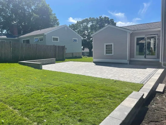 a house with a large lawn in front of it and a driveway leading to it