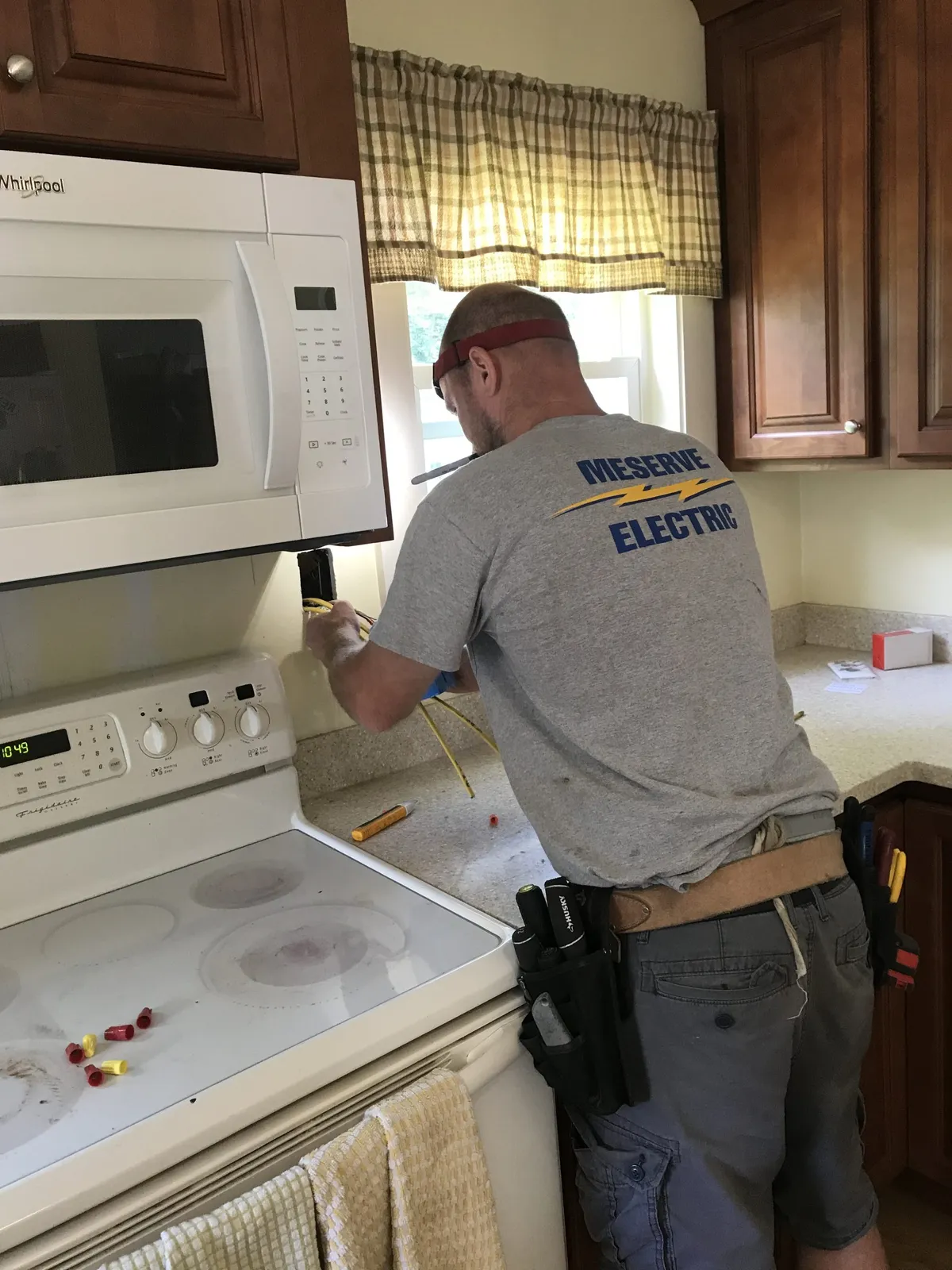 Electricians repairing kitchen appliances and residential wiring