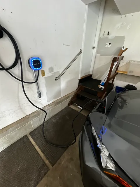 Electric Vehicle Charger Installed in a Garage with Car Plugged In
