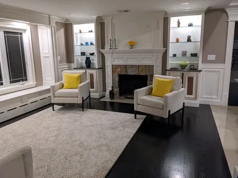 Living room with fireplace, two armchairs, and rug