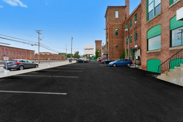 A parking lot with cars parked in front of a brick building