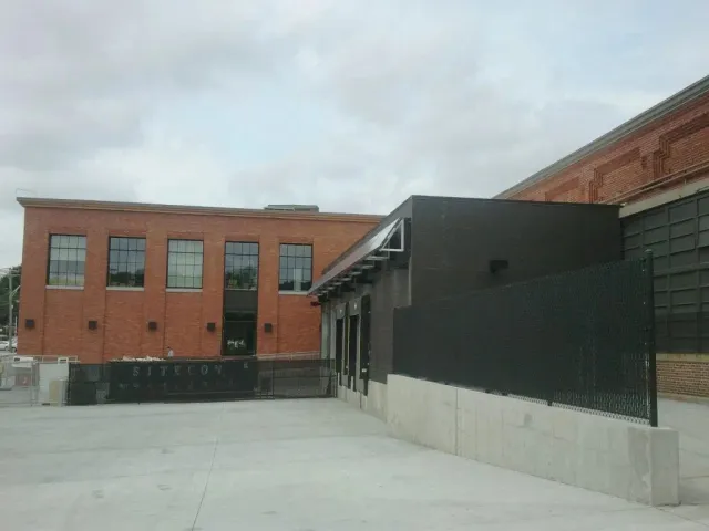 A large brick building with a black fence in front of it