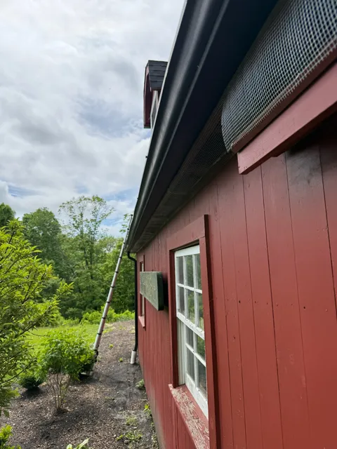 Full eave line mesh exclusion barrier installation on red building